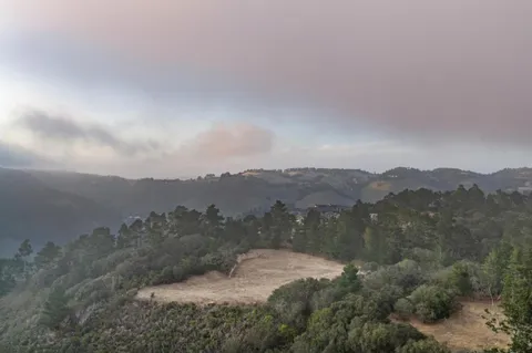 an aerial view of mountain with trees around