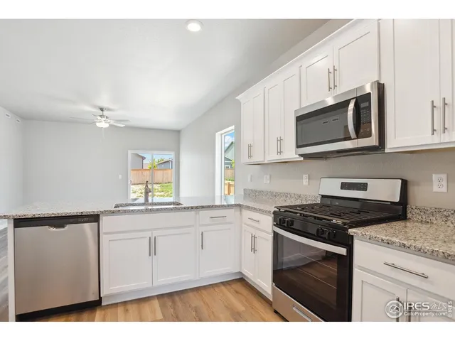 a kitchen with stainless steel appliances white cabinets and a stove top oven