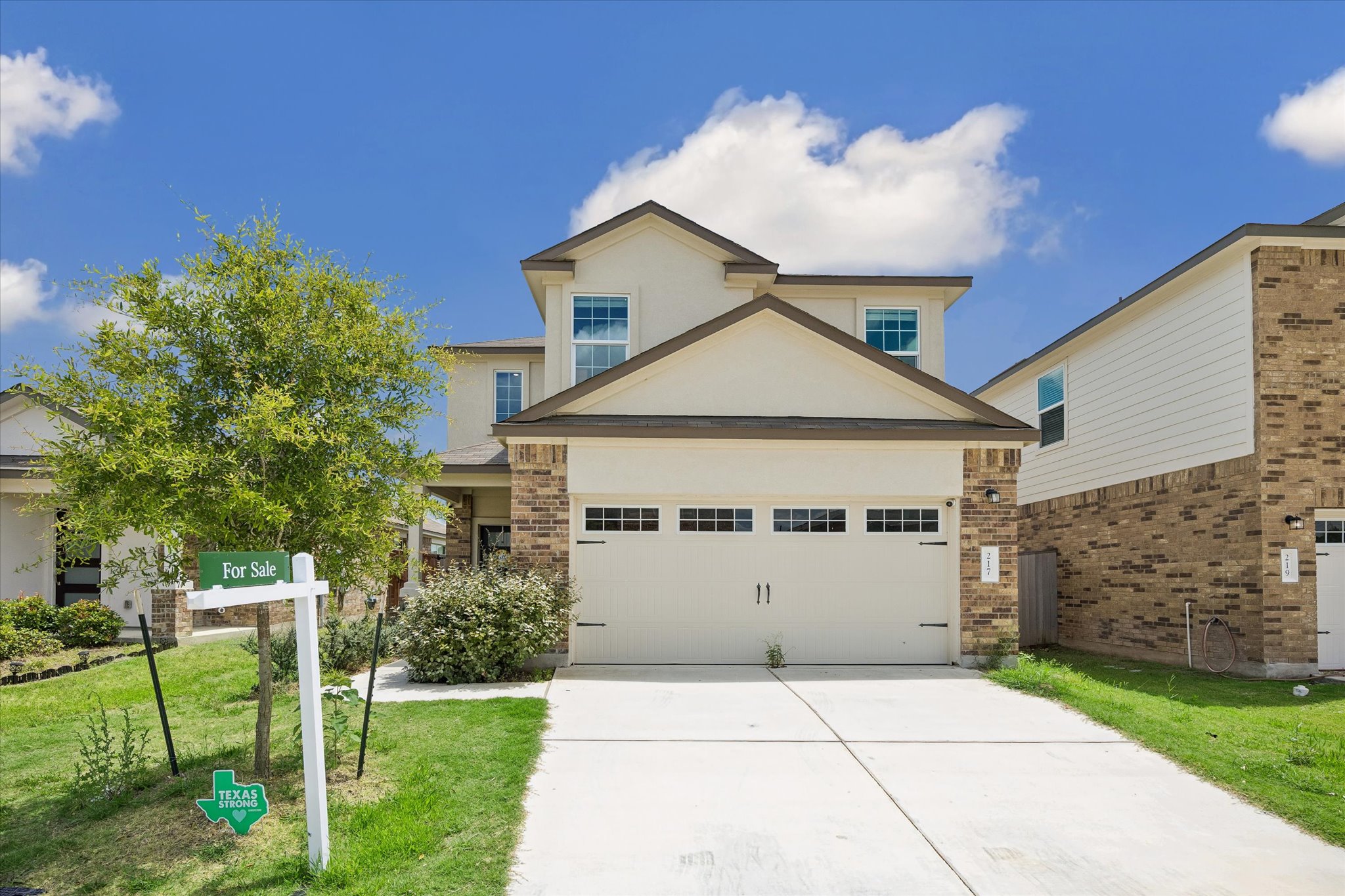 217 Canley Loop Hutto, TX 78634 - Photo 1 of 36 A cream-colored garage door with decorative windows accents this modern home's welcoming facade.