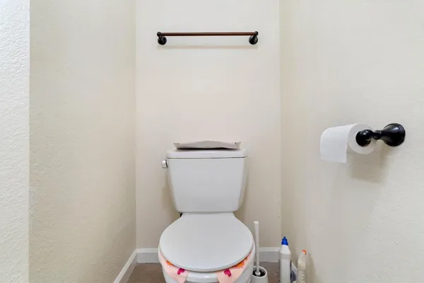 a white toilet sitting next to a white wall