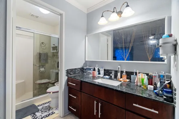 a bathroom with a sink vanity granite and toilet