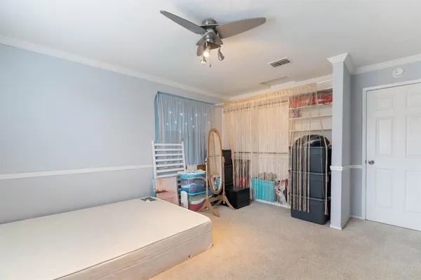 a bedroom with a bed a dresser and a chandelier