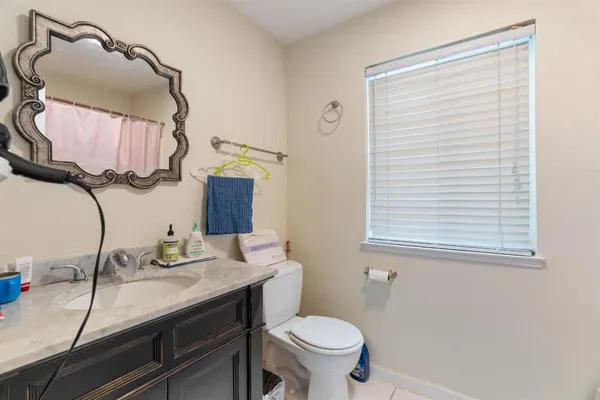 a bathroom with a sink vanity granite and toilet
