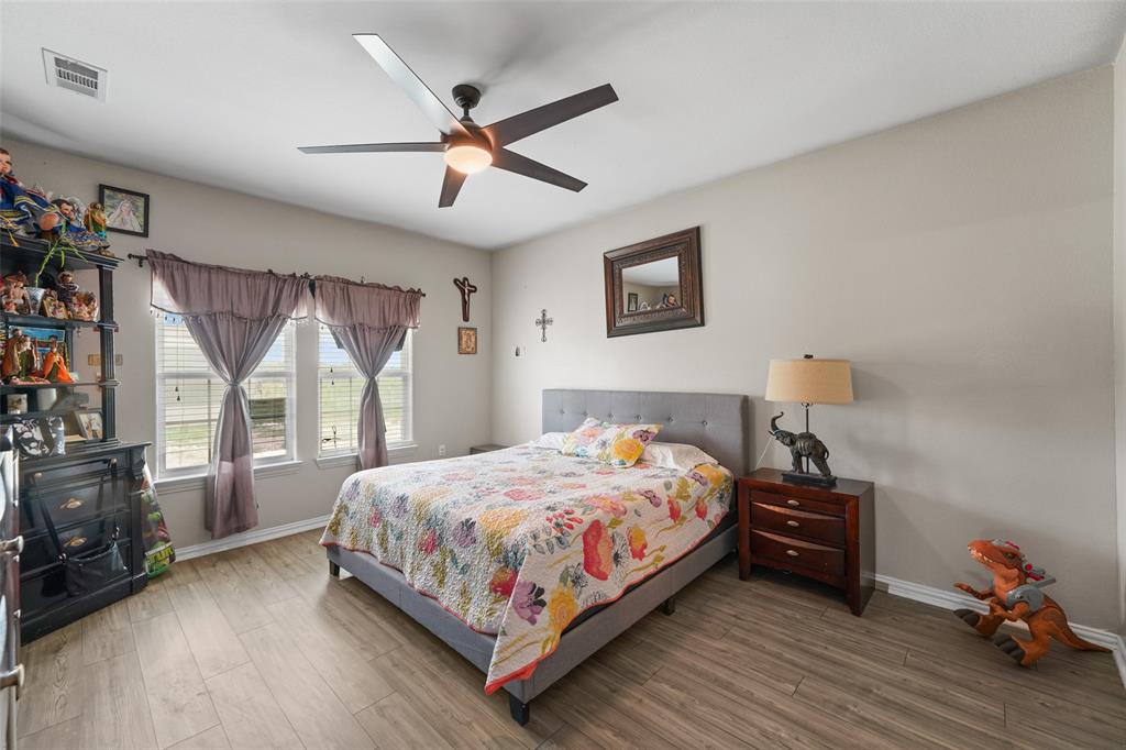 0 Ewing Road Ferris, TX 75125 - Photo 8 of 29 Bedroom featuring wood-finish flooring, a contemporary ceiling fan with integrated lighting, and multiple windows for natural light
