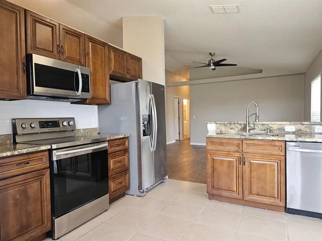 a kitchen with stainless steel appliances granite countertop a stove microwave and refrigerator