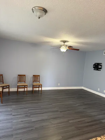 a view of a room with wooden floor table and chairs