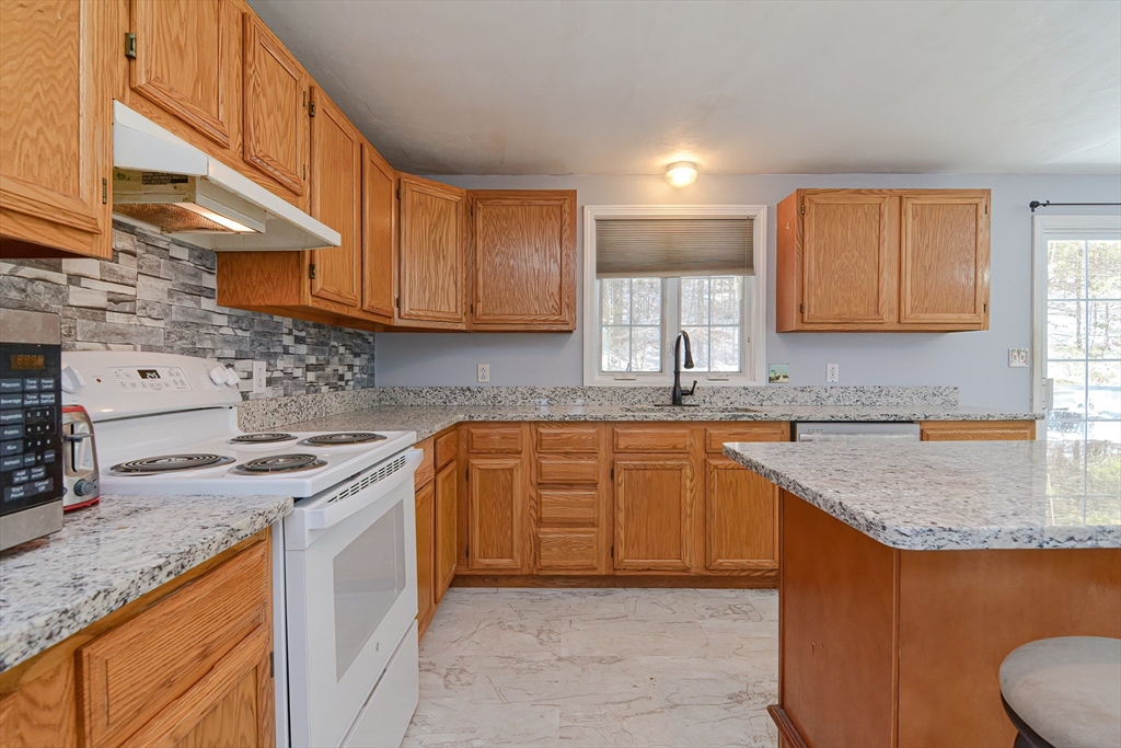 38 Clark Road Sturbridge, MA 01518 - Photo 8 of 30 a kitchen with stainless steel appliances granite countertop a sink stove and cabinets