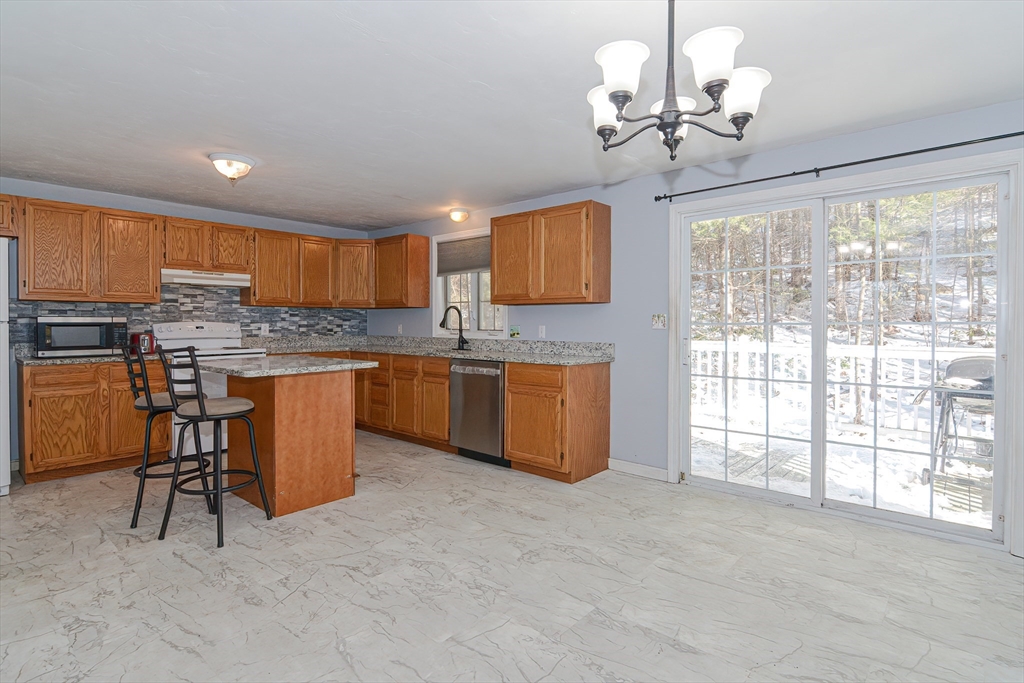 38 Clark Road Sturbridge, MA 01518 - Photo 10 of 30 a kitchen with stainless steel appliances granite countertop a stove top oven a sink dishwasher a dining table and chairs with wooden floor