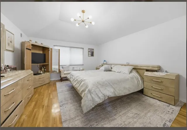 a spacious bedroom with a bed and a chandelier