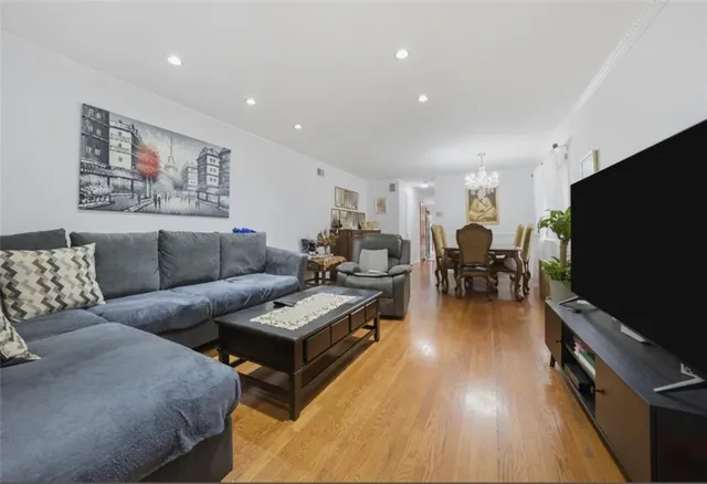 a living room with furniture flat screen tv and wooden floor