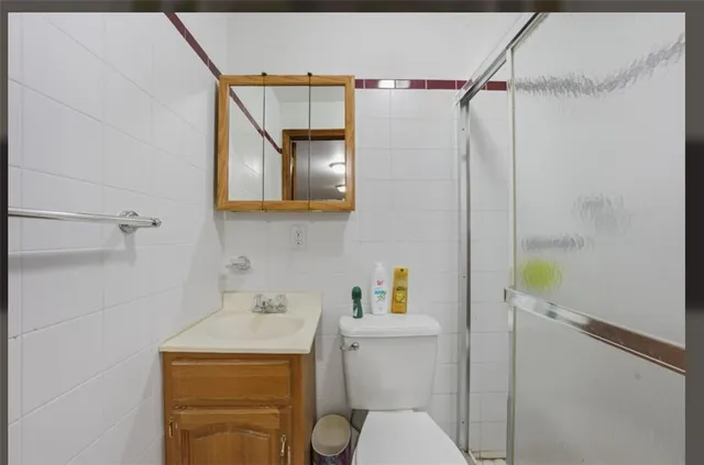 a bathroom with a sink a toilet and shower