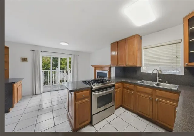 a kitchen with stainless steel appliances granite countertop a stove a sink and a microwave