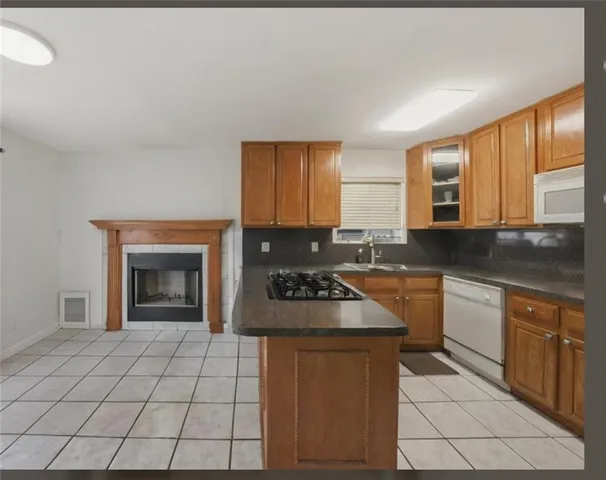 a kitchen with granite countertop a stove sink and cabinets