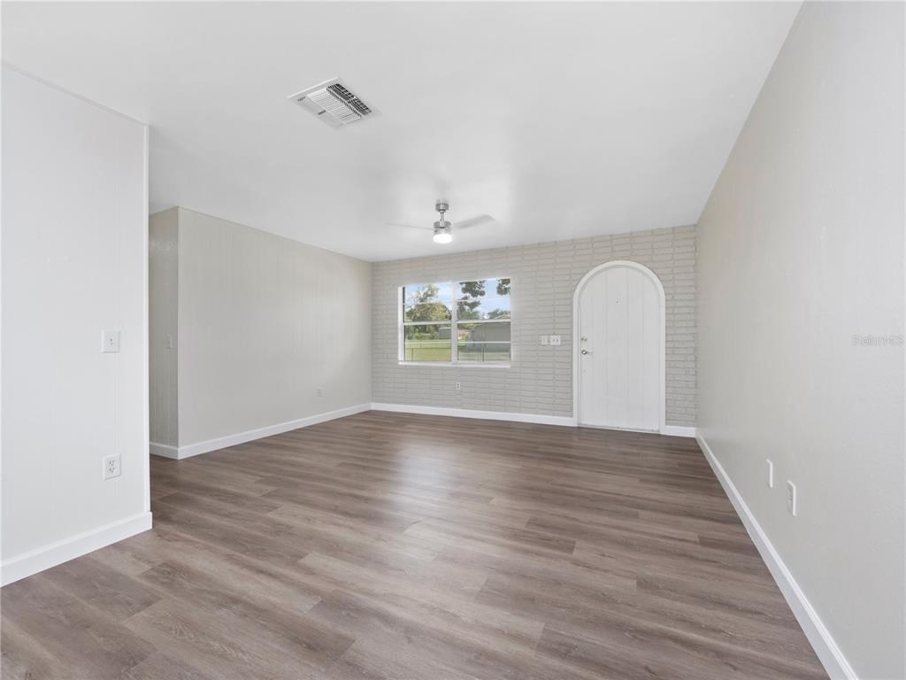 5400 Fox Briar Trail Orlando, FL 32808 - Photo 11 of 31 a view of an empty room with wooden floor and a window