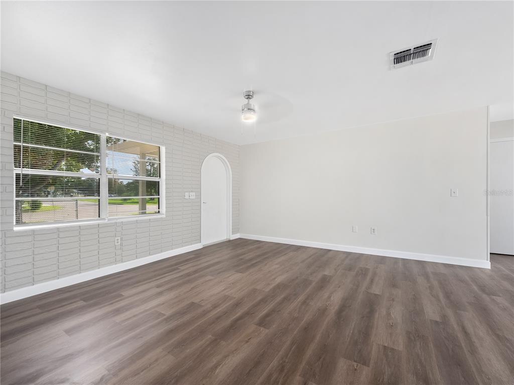5400 Fox Briar Trail Orlando, FL 32808 - Photo 12 of 31 a view of an empty room with wooden floor and a window