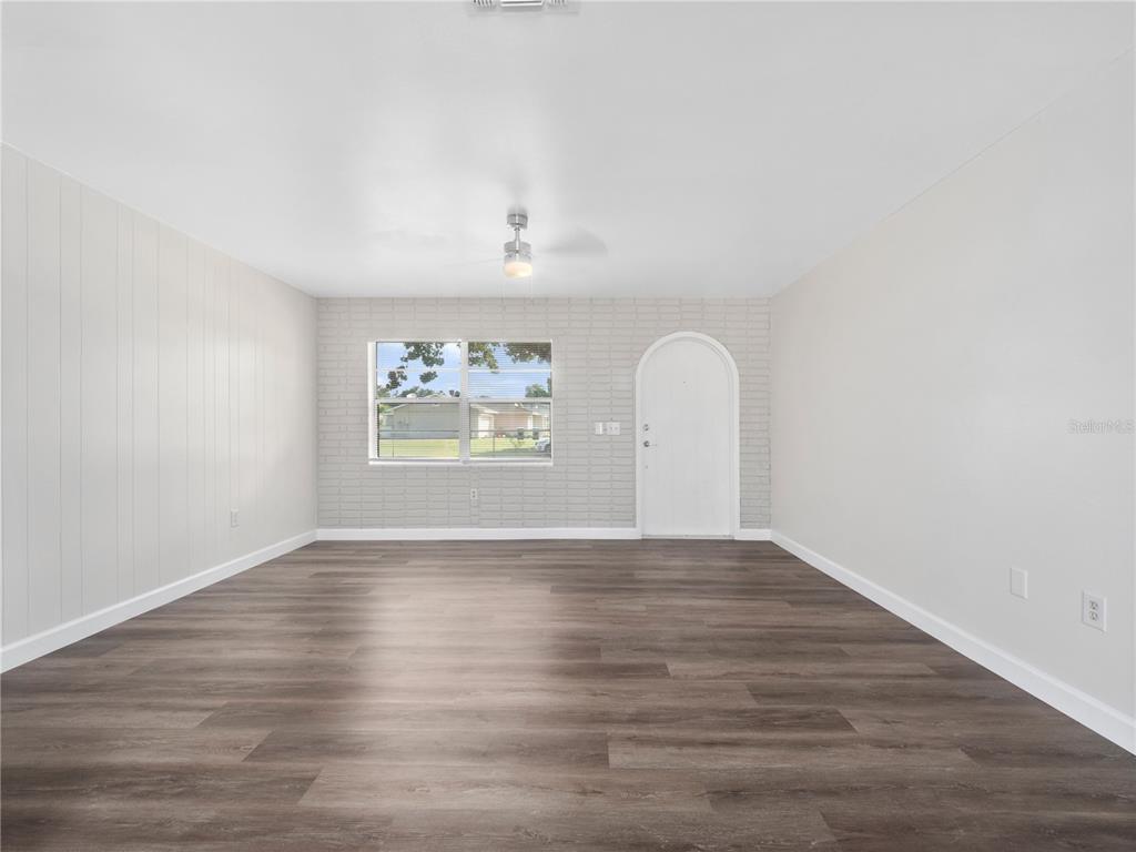 5400 Fox Briar Trail Orlando, FL 32808 - Photo 13 of 31 a view of an empty room with wooden floor and a window