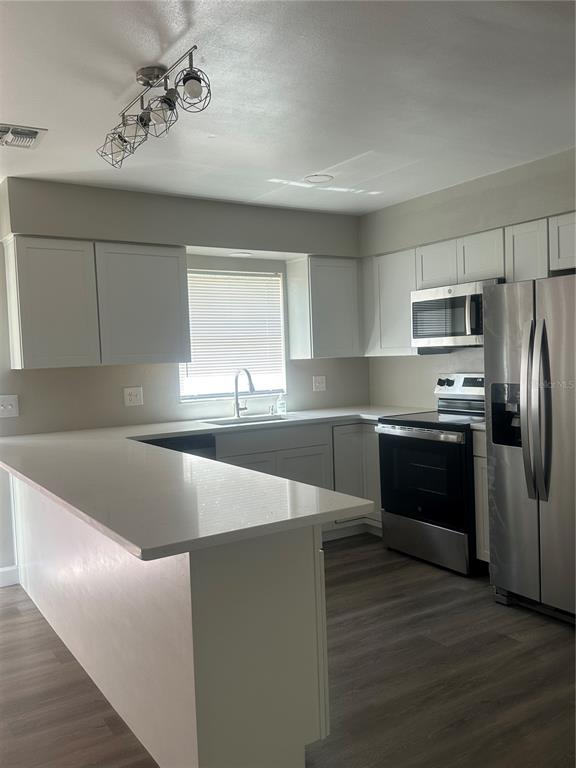5400 Fox Briar Trail Orlando, FL 32808 - Photo 7 of 31 a kitchen with stainless steel appliances a refrigerator sink and cabinets