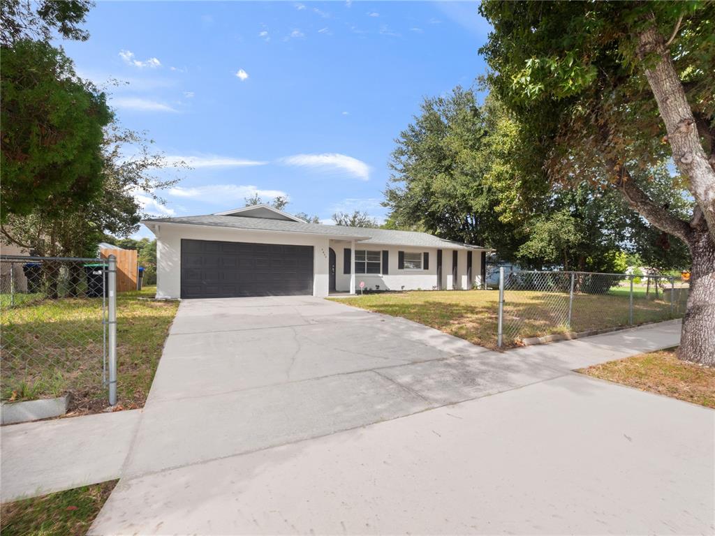 5400 Fox Briar Trail Orlando, FL 32808 - Photo 10 of 31 a front view of a house with a garden and yard