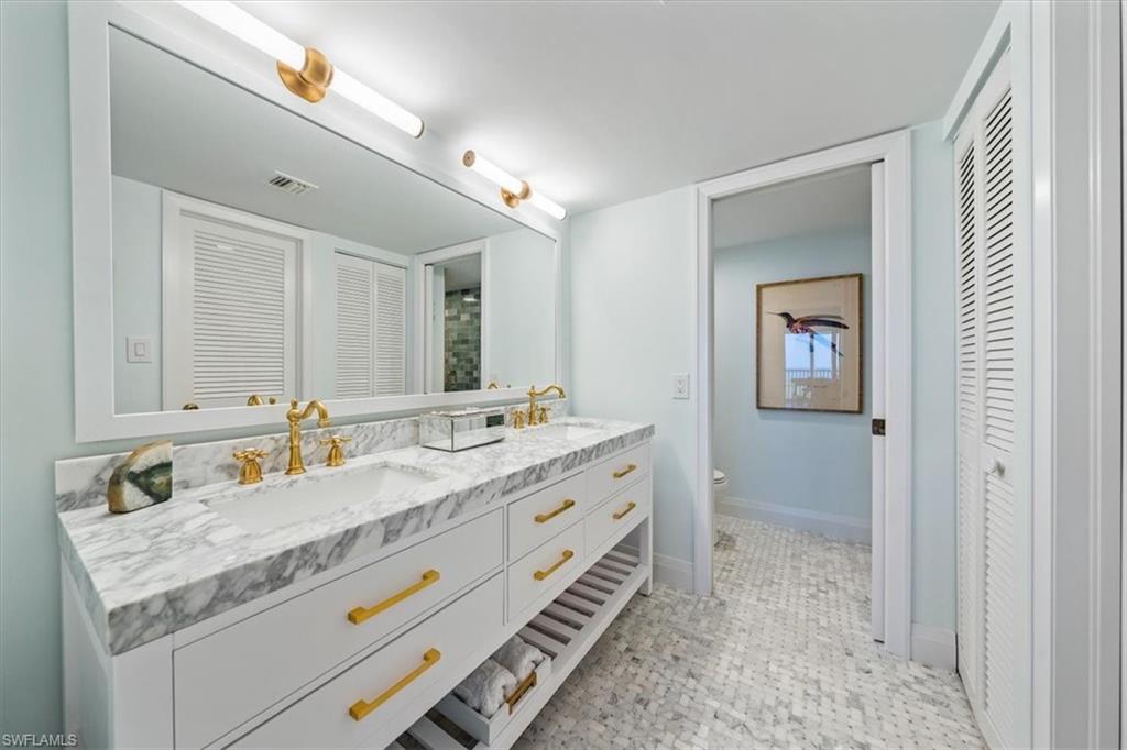 6573 Marissa Loop, Unit 1002 Naples, FL 34108 - Photo 10 of 24 a bathroom with a granite countertop double vanity sink and mirror