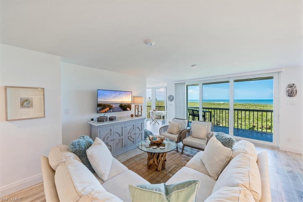 6573 Marissa Loop, Unit 1002 Naples, FL 34108 - Photo 2 of 24 a living room with furniture and a flat screen tv