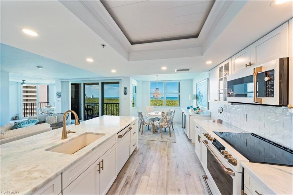 6573 Marissa Loop, Unit 1002 Naples, FL 34108 - Photo 5 of 24 a large kitchen with stainless steel appliances granite countertop a lot of counter space and a wooden floors