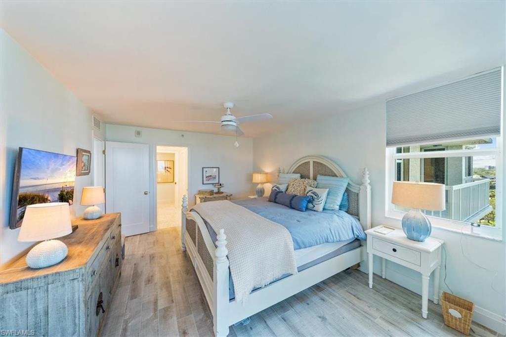 6573 Marissa Loop, Unit 1002 Naples, FL 34108 - Photo 9 of 24 a bedroom with a bed and wooden floor