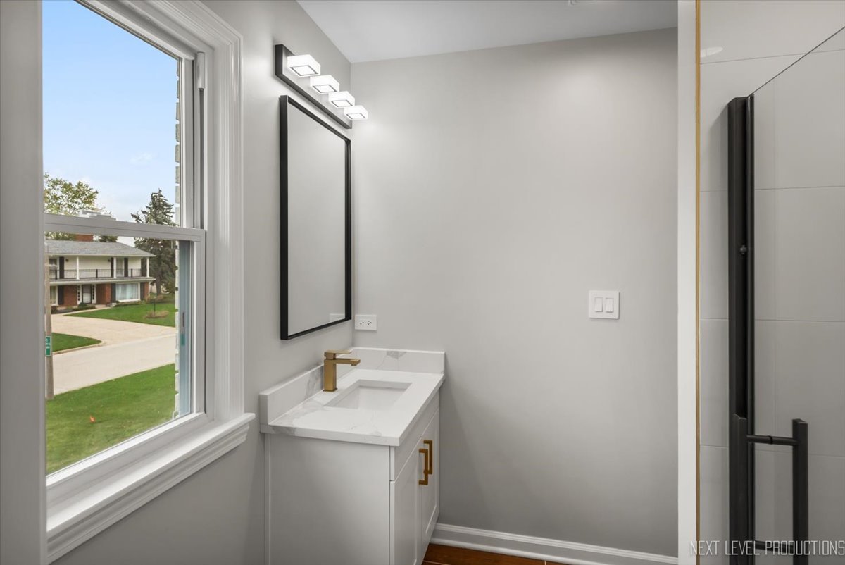 27 South Canterbury Road Aurora, IL 60506 - Photo 17 of 39 a bathroom with a sink a mirror and a shower