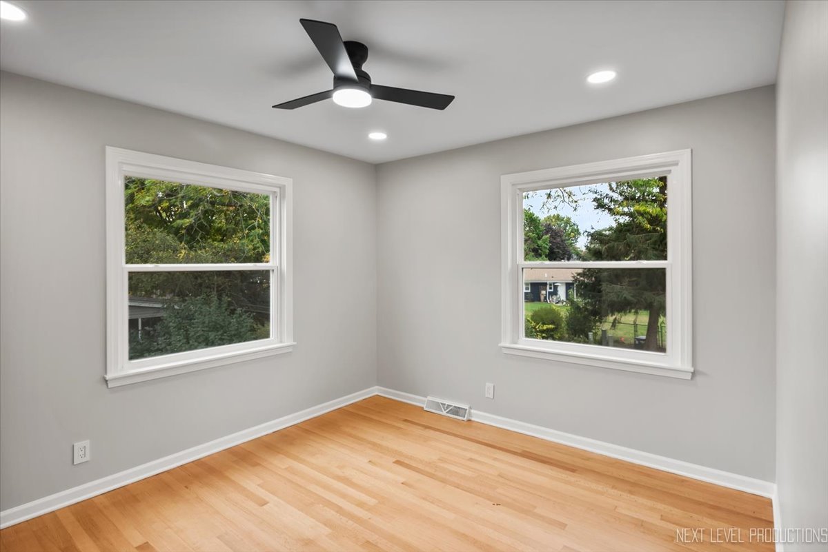 27 South Canterbury Road Aurora, IL 60506 - Photo 22 of 39 a view of an empty room with wooden floor and a window