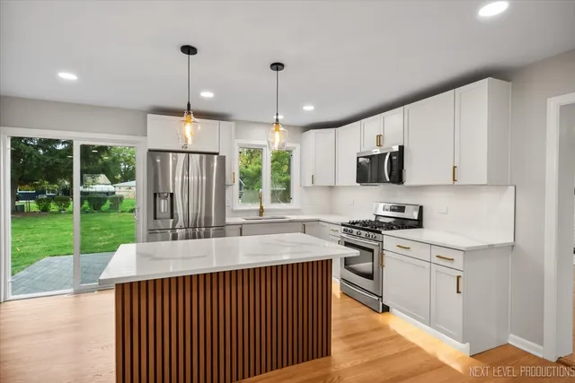 a bathroom with a granite countertop sink a large mirror a and window