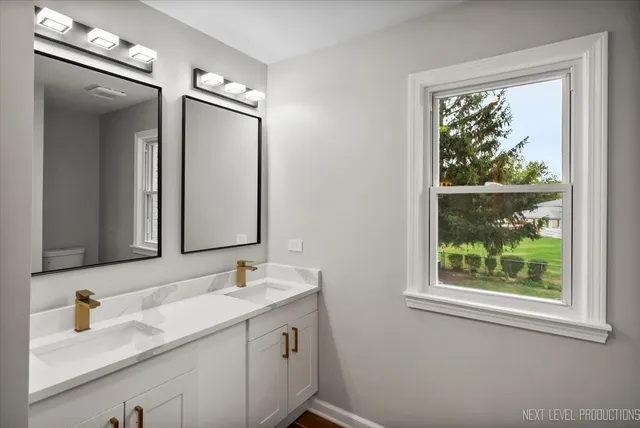 a bathroom with a granite countertop sink toilet and mirror