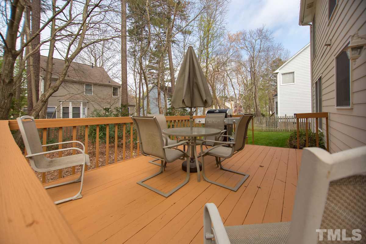 12113 Ranleigh Court Raleigh, NC 27613 - Photo 22 of 22 a view of a patio with table and chairs and wooden fence
