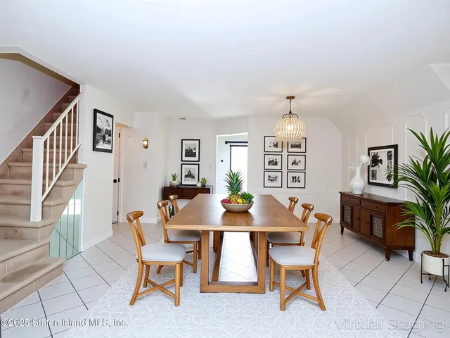 a dining room with furniture a large window and a chandelier