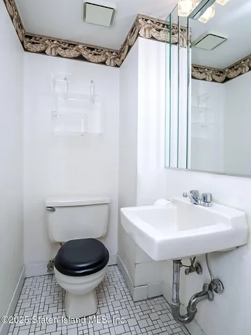 a bathroom with a sink a toilet and a mirror