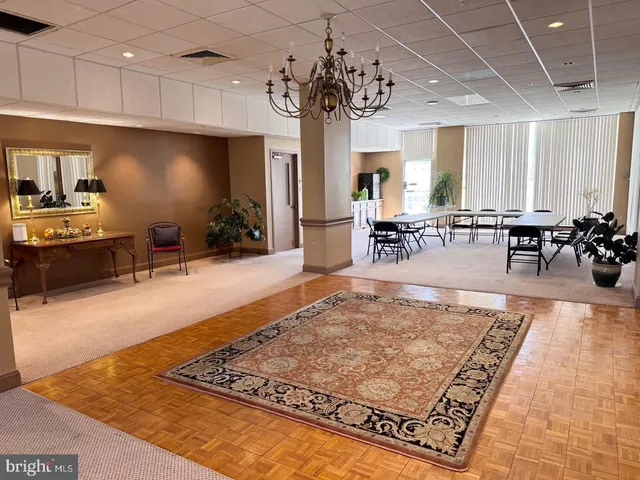 a living room with furniture a dining table and large windows