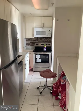 a kitchen with stainless steel appliances granite countertop a refrigerator a stove and a sink