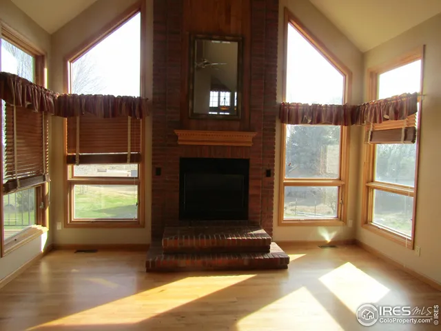 a living room with a fireplace furniture and a large window