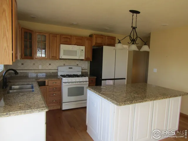 a kitchen with stainless steel appliances granite countertop a sink a stove and a refrigerator