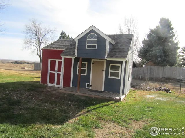 a view of a house with backyard and a tree