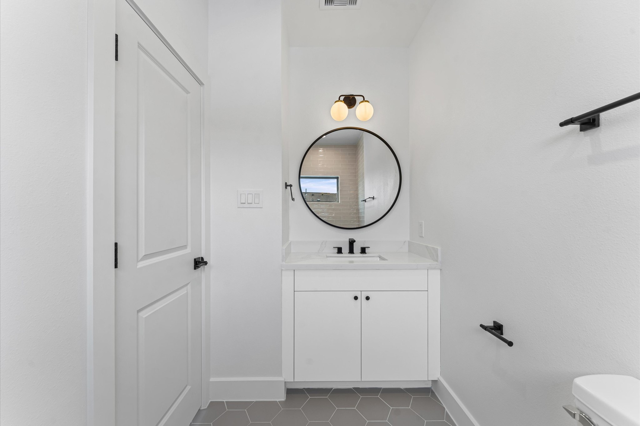 1122 West 17th Street, Unit E Houston, TX 77008 - Photo 32 of 37 a bathroom with a toilet a sink and a mirror