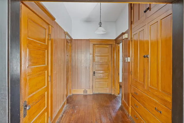a view of a hallway with wooden floor and a door