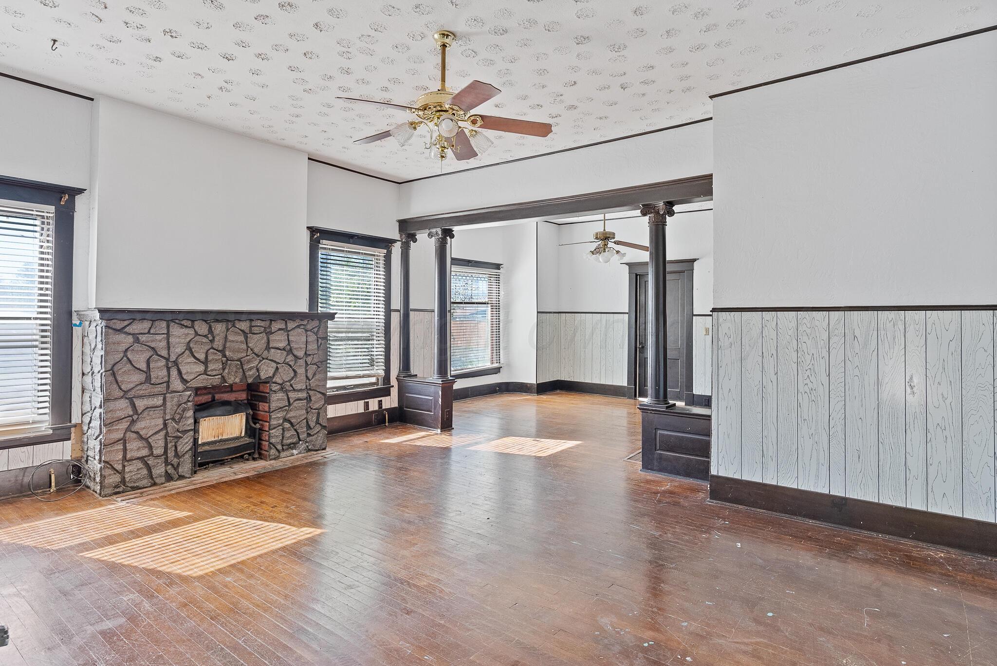 4124 Crockett Street Amarillo, TX 79110 - Photo 3 of 25 an empty room with windows fireplace and wooden floor