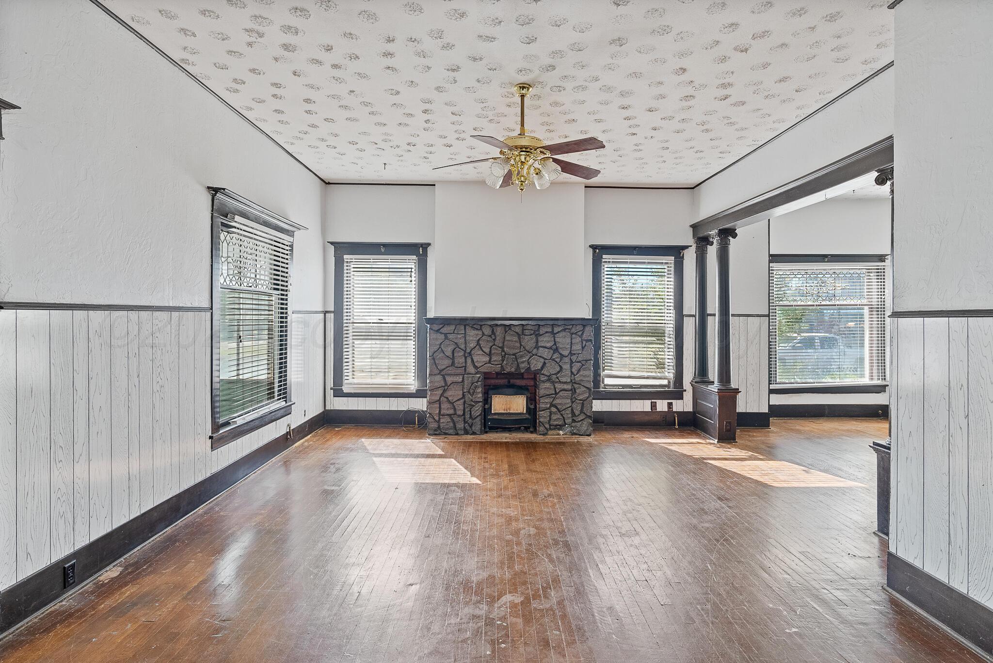 4124 Crockett Street Amarillo, TX 79110 - Photo 4 of 25 a view of an empty room with wooden floor fireplace and a window