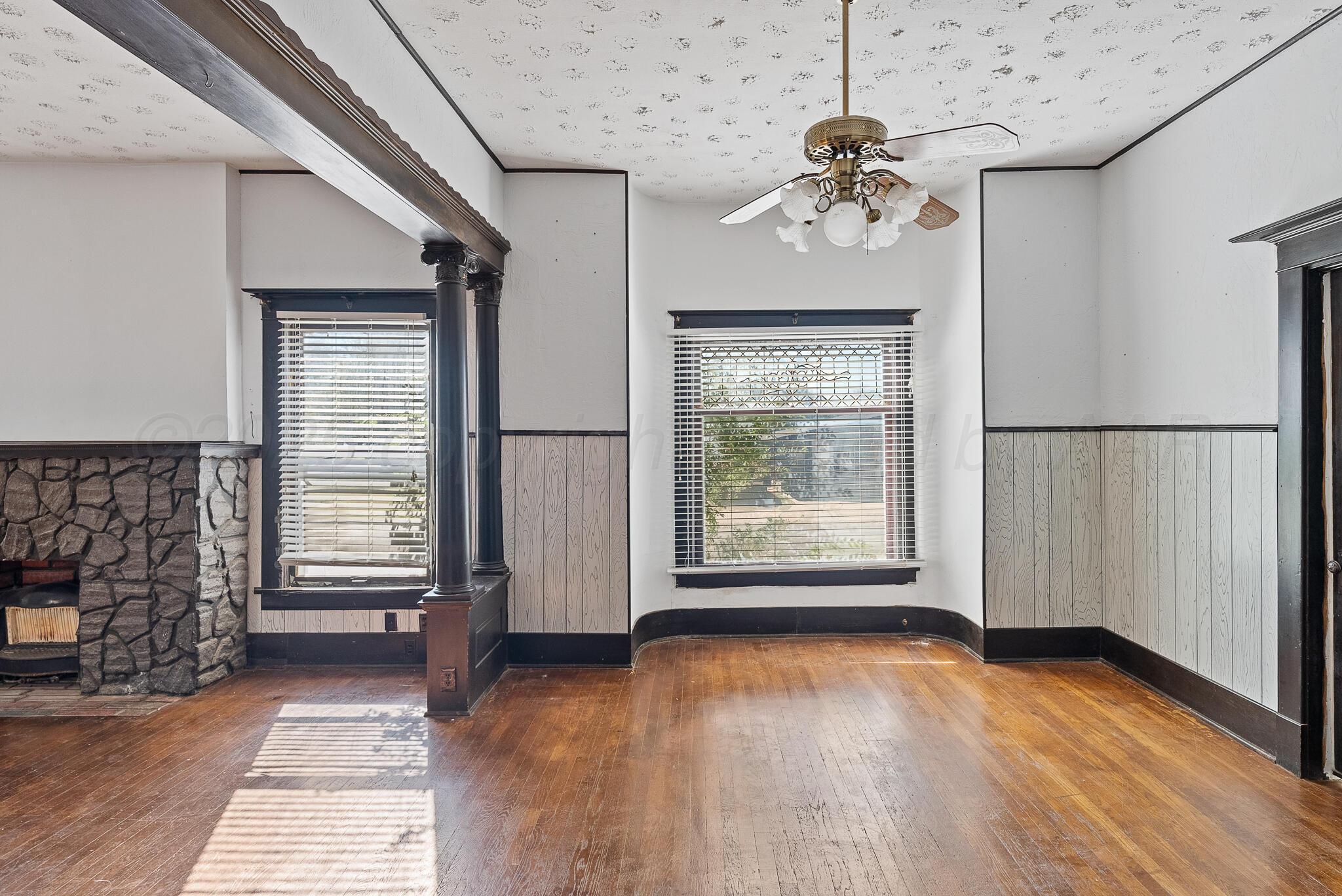 4124 Crockett Street Amarillo, TX 79110 - Photo 6 of 25 an empty room with wooden floor chandelier and windows
