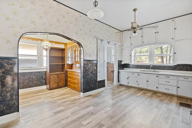 a view of a big room with wooden floor and windows