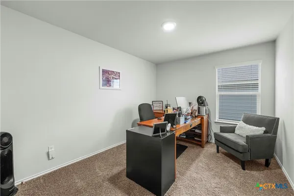 a view of a workspace with furniture and a window