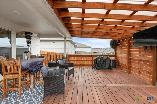 a view of a roof deck with table and chairs barbeque with wooden floor
