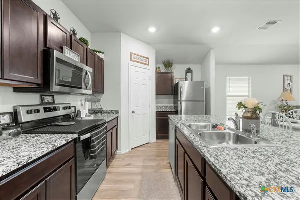 a kitchen with granite countertop stainless steel appliances and wooden cabinets