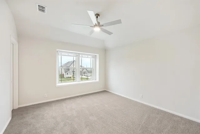 an empty room with a window and a ceiling fan