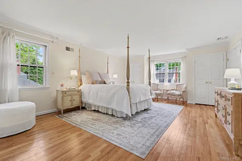 a spacious bedroom with a bed and wooden floor