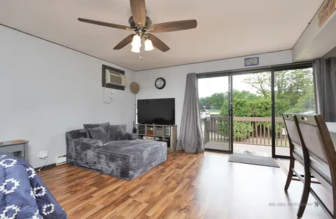 a living room with furniture a flat screen tv and a large window